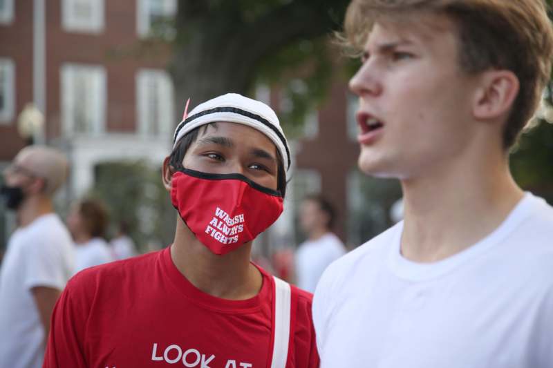 a man wearing a face mask and talking to another man
