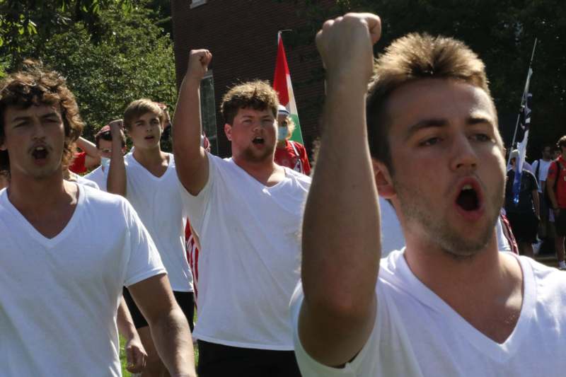 a group of men in white shirts with their fists raised