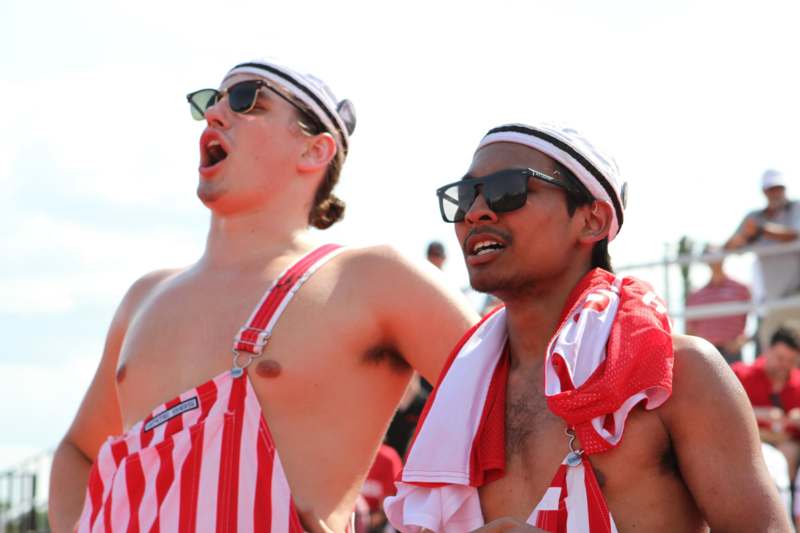 two men wearing red and white striped overalls and sunglasses