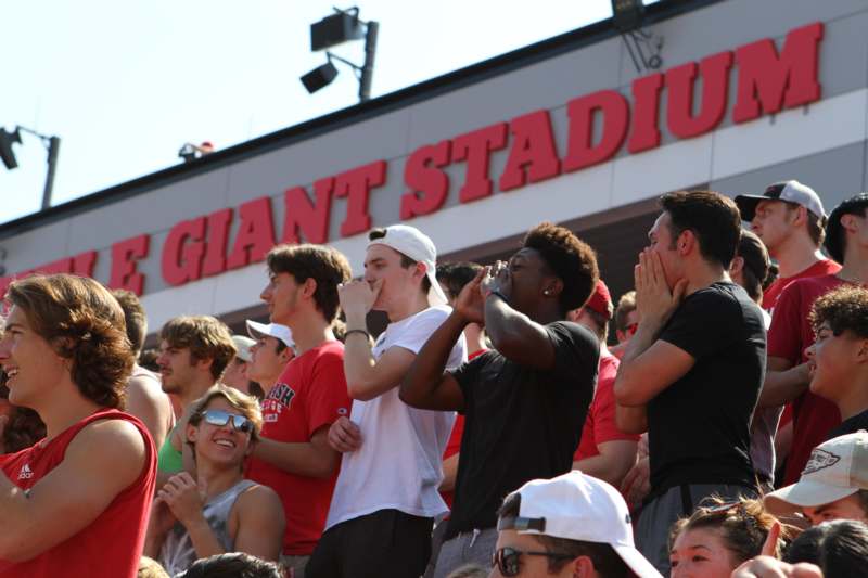 a group of people standing in bleachers