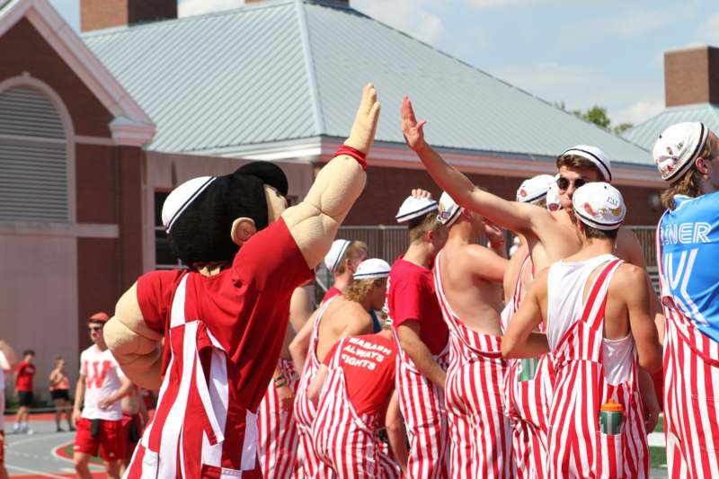 a group of people in striped uniforms high fiving