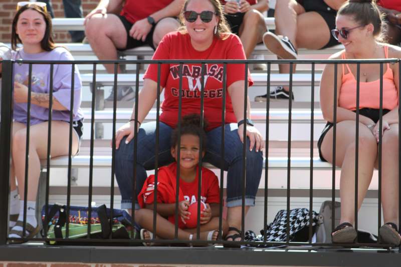 a woman and child sitting on bleachers