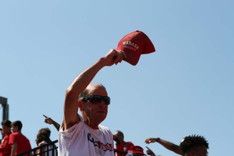 a man holding up a red hat