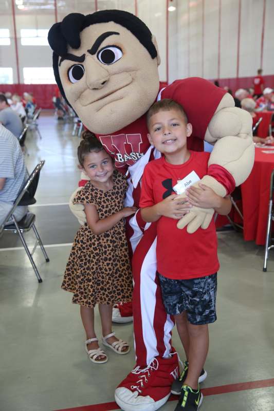 a boy and girl posing with a mascot