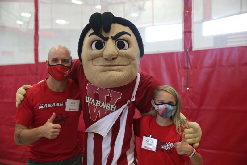 a man and a woman posing with a mascot