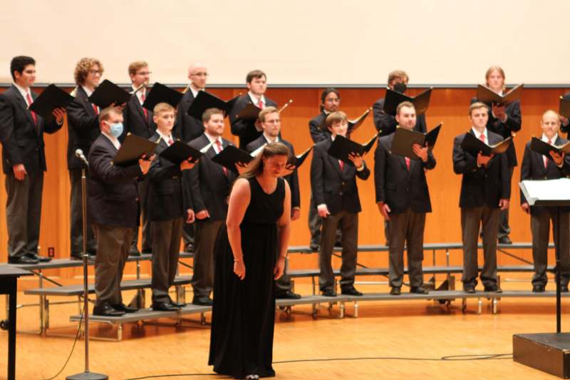a group of people singing in front of a choir