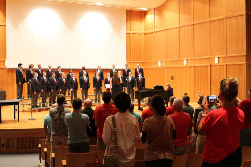 a group of people in suits performing in front of a group of people