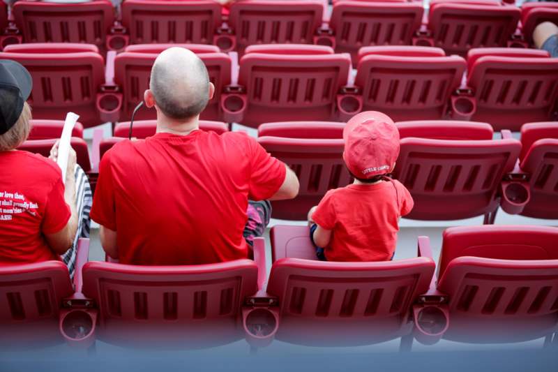 a man and child sitting in a stadium seat
