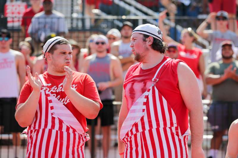 a group of men wearing red and white striped overalls