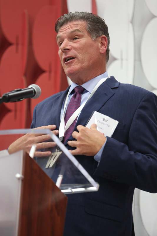 a man standing at a podium speaking into a microphone