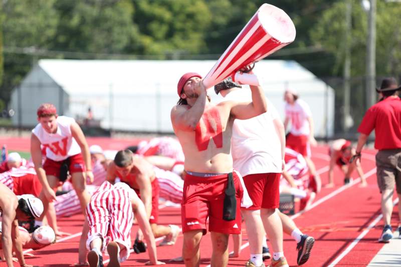 a man in red shorts and headband holding a megaphone