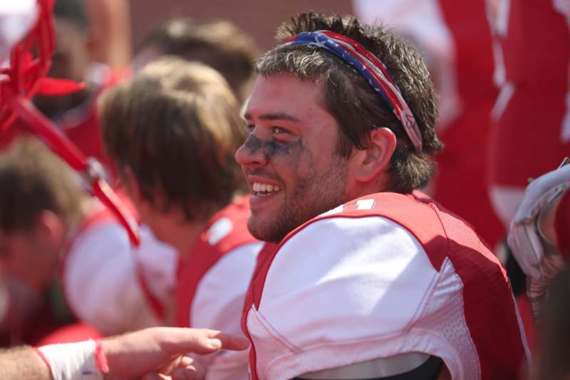 a football player smiling with a dirty face