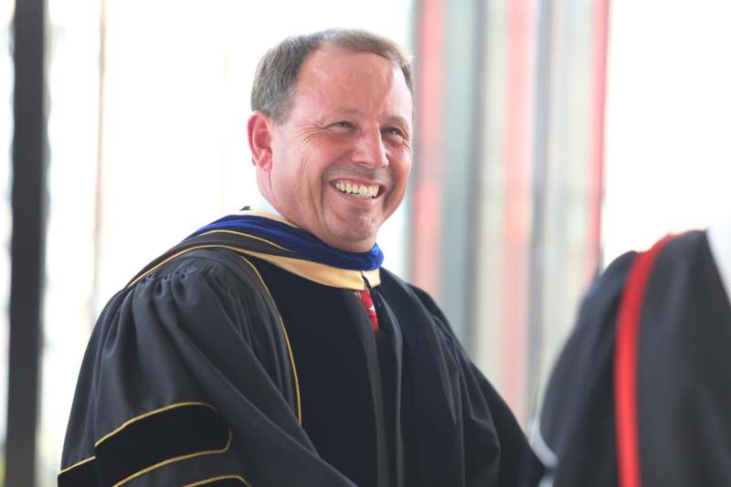 a man in a black robe smiling