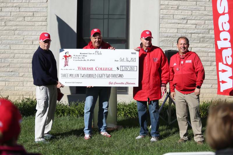 a group of men holding a large check