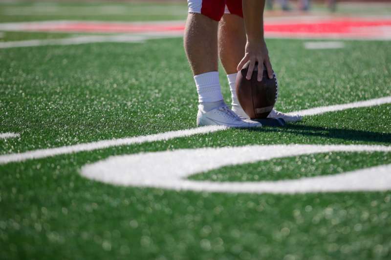 a person holding a football on a football field