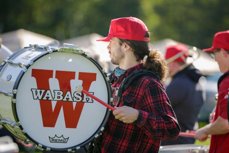 a man in a red hat playing a drum