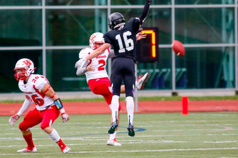 a football player in a black uniform throwing a football