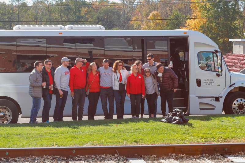 a group of people standing in front of a bus