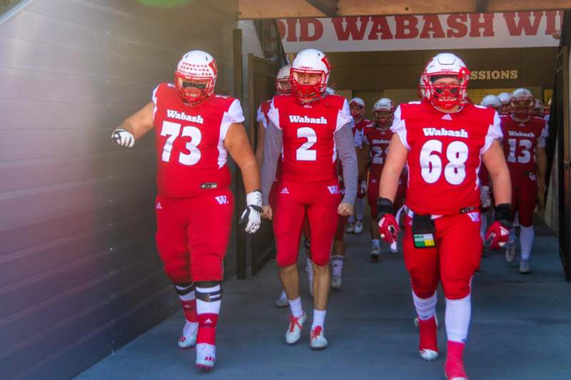 a group of football players walking down a walkway