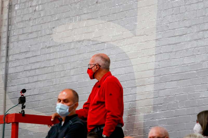 a man in a red shirt wearing a face mask