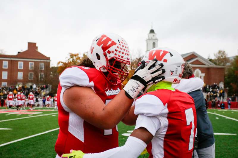two football players hugging on a field