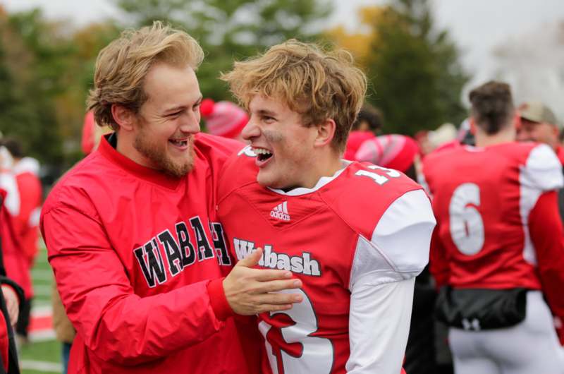 two men in football uniforms laughing