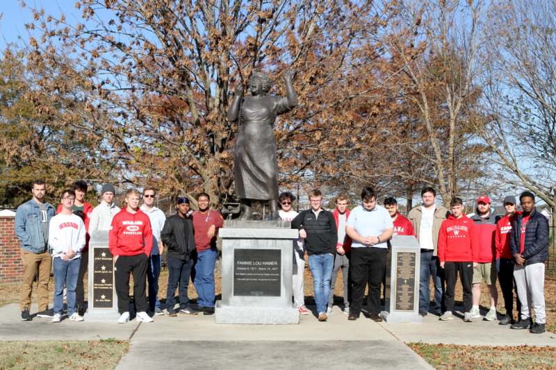 a group of people standing in front of a statue