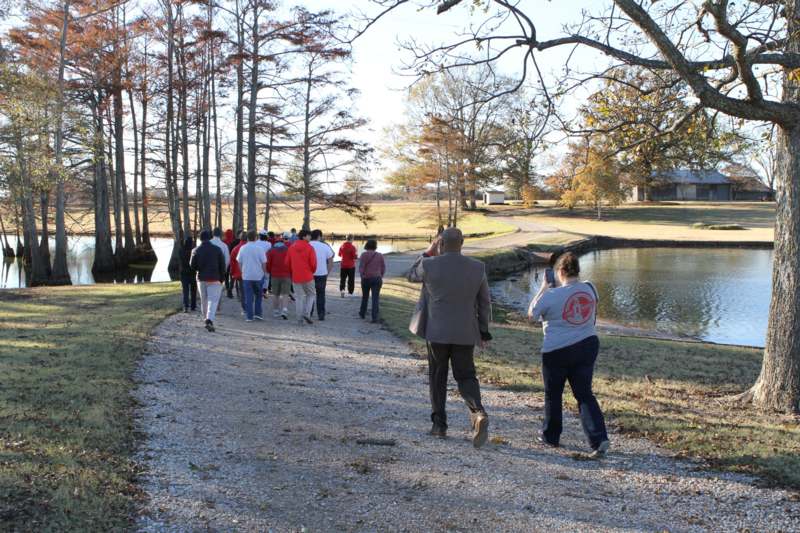 a group of people walking on a path near a body of water
