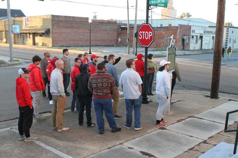 a group of people standing on a street corner