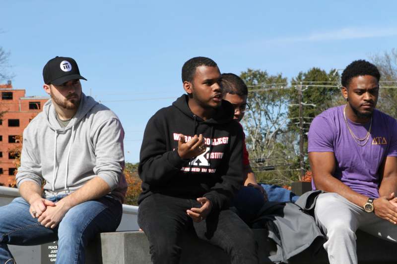 a group of men sitting on a concrete ledge
