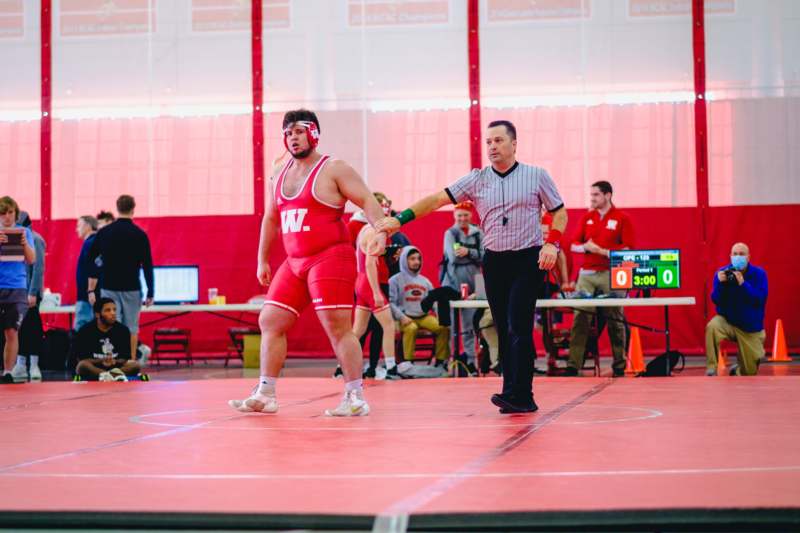 a man in a red uniform on a wrestling mat