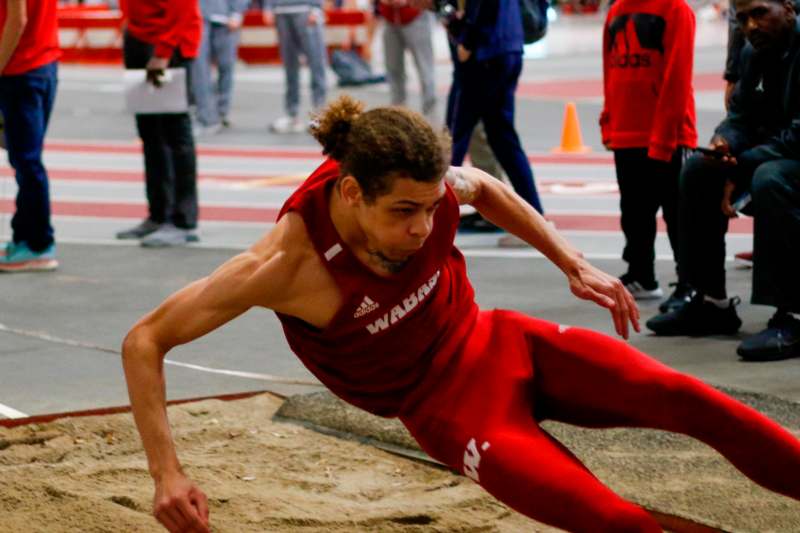 a man in a red uniform running on a track