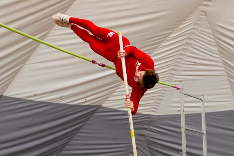 a man in red jumpsuit holding a pole in the air