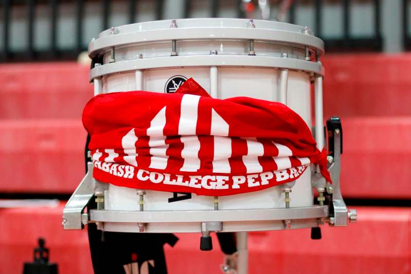 a white drum with a red scarf around it