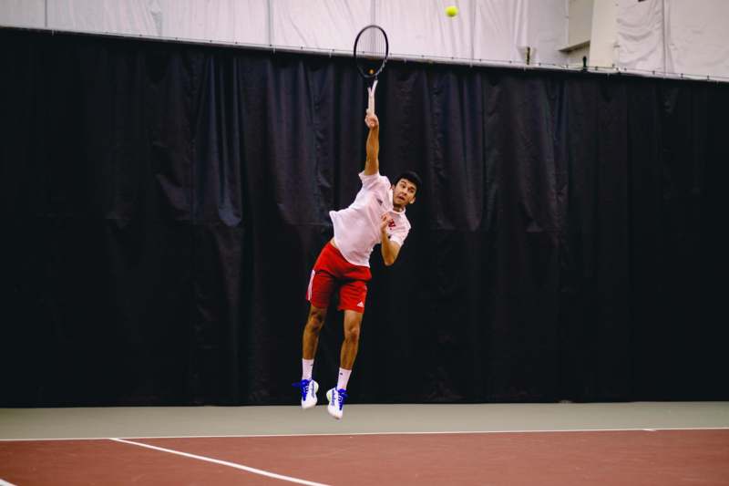 a man jumping in the air with a tennis racket