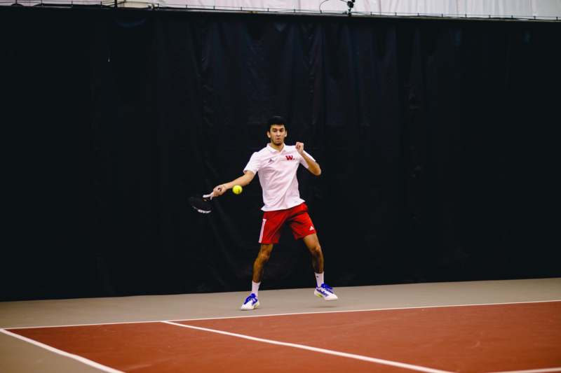 a man holding a tennis racket and ball