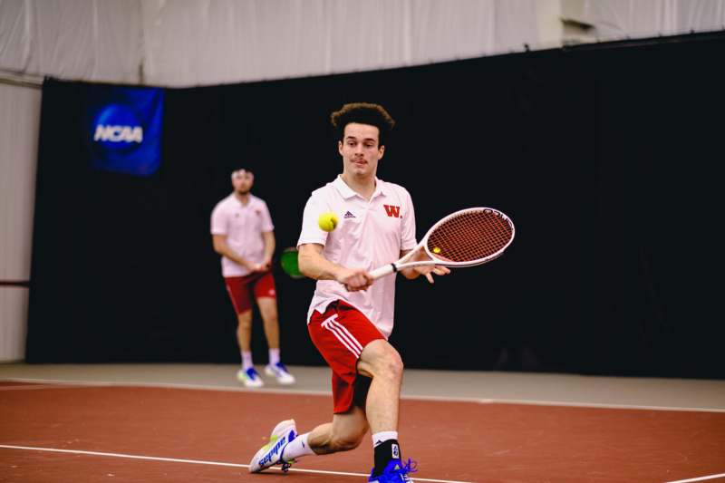 a man holding a tennis racket and a ball