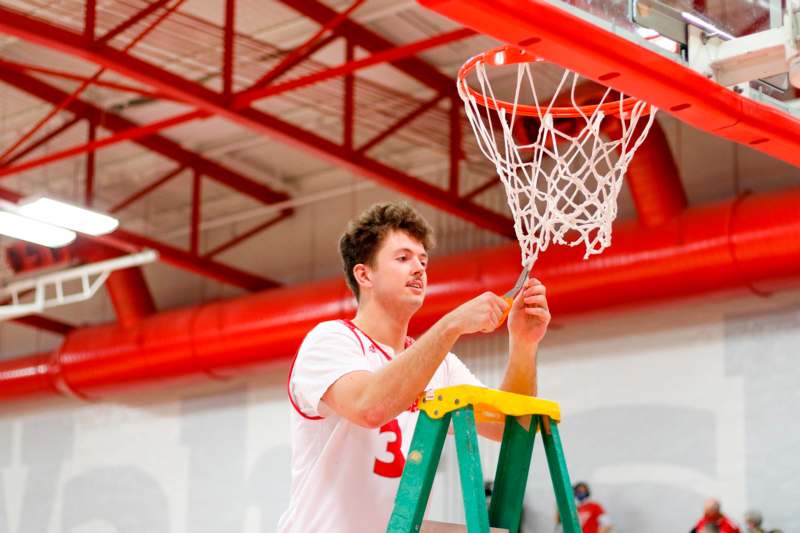 a man on a ladder holding a basketball hoop