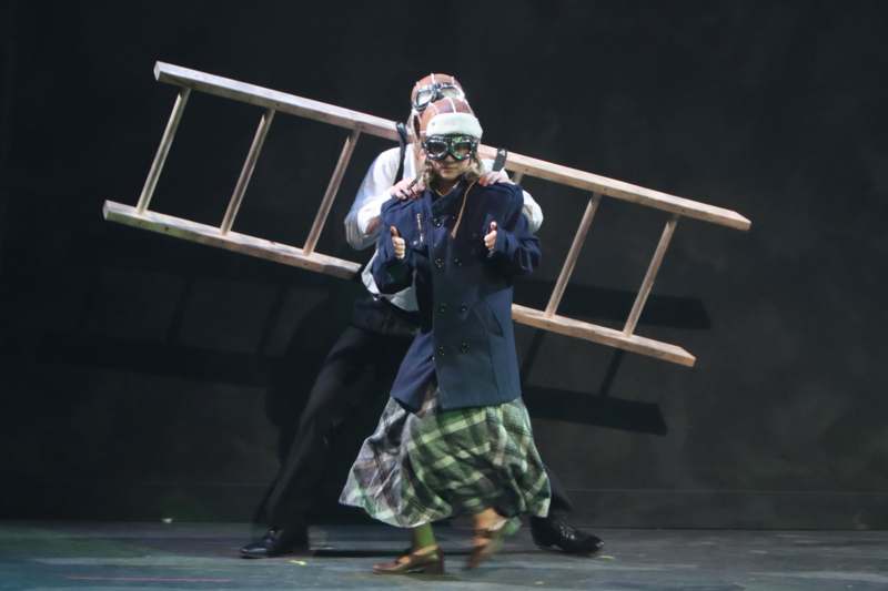 a man and woman wearing goggles and a wooden ladder