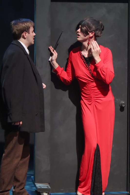 a man in a black coat and a woman in a red dress