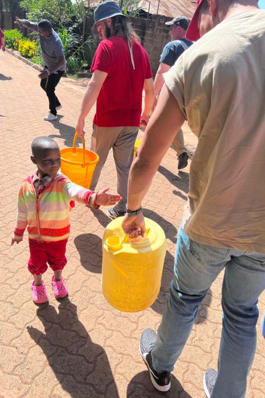 a group of people holding buckets and a child