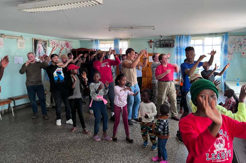 a group of people standing in a room with their hands up