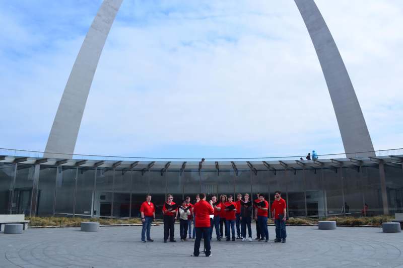 a group of people standing in front of a large arch