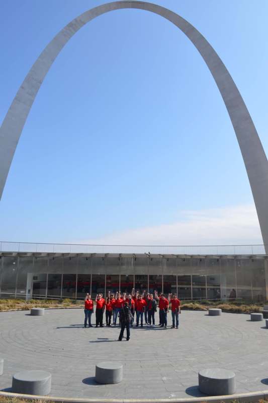 a group of people standing in front of a large arch