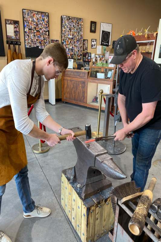 a man and a man working on anvil