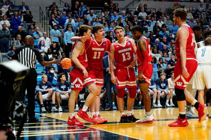 a group of men in red uniforms on a basketball court