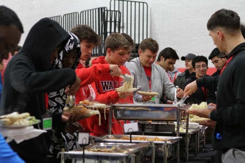 a group of people in red hoodies serving food