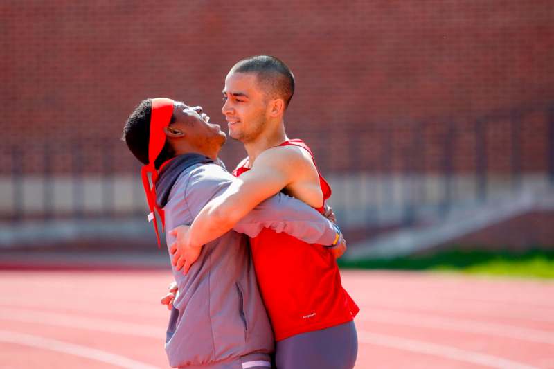 two men hugging on a track