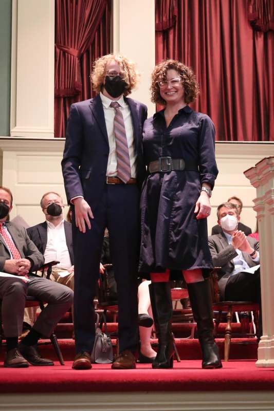 a man and woman standing on a stage with masks