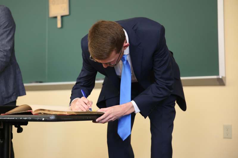 a man in a suit writing on a paper